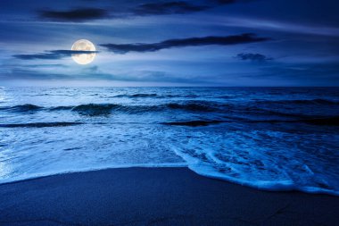 Yaz tatili konsepti için deniz kıyısındaki kumsal. Mükemmel sahilde güzel bir gece, sakin dalgalar ve bulutlar dolunay ışığında gökyüzünde. Yatırım veya soyut kavramların finansmanı için manzara