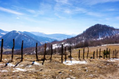 Güneşli bir günde dikenli tellerle kaplı kar tepesi. Yeşil çevre sürdürülebilirliği ve korunması. Dünya Günü için arkaplan