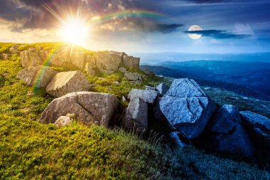 Yazın kayalarla kaplı dağ manzarası. Gündüz ve gece zaman kavramını değiştirir. Alacakaranlıkta güneş ve ay ile gökyüzünün altında çimenler. Alp çayırı ve kayalarla yuvarlanan tepeler. eşitlik ve kayma şablonu