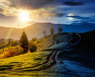 Otlak yamaçlı kırsal alan. Gündüz ve gece zaman kavramını değiştirir. Yuvarlanan tepelerden geçen toprak yol boyunca tahta çitler. Baharda güneş ve ay ile birlikte dağların manzarası