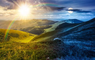 Yazın dağ manzarası. Gündüz ve gece değişiyor. Güneşli ve aylı bir yamacın kenarındaki çimenli çayırların arasında bir taş. Keşif için dağlık arazi ve benekli ışıkta gezgin şehvet
