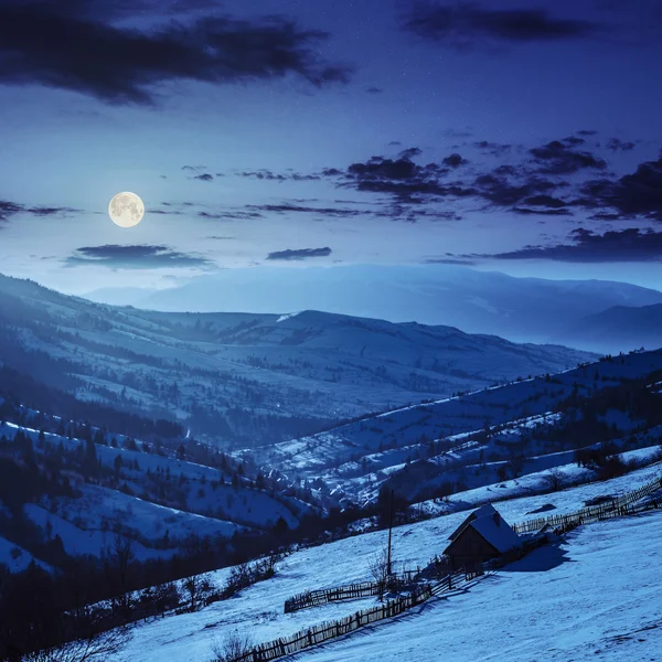 Cobertizo de madera en la ladera en las montañas de invierno por la noche — Foto de Stock