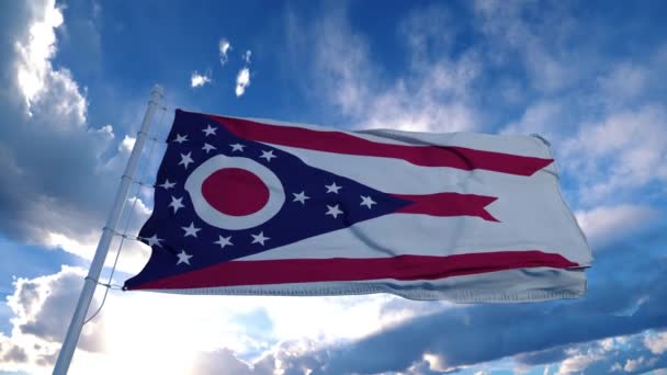 Ohio zászló egy zászlórúdon integet a szélben, kék ég háttér. 4K — Stock videók