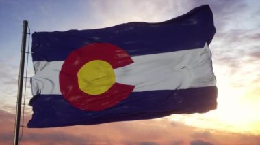 Colorado bayrağı gün batımında güzel gökyüzüne karşı rüzgarda dalgalanıyor.