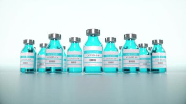 Ampullerde Coronavirus aşısı laboratuvar masasının mavi arka planına yakın plan