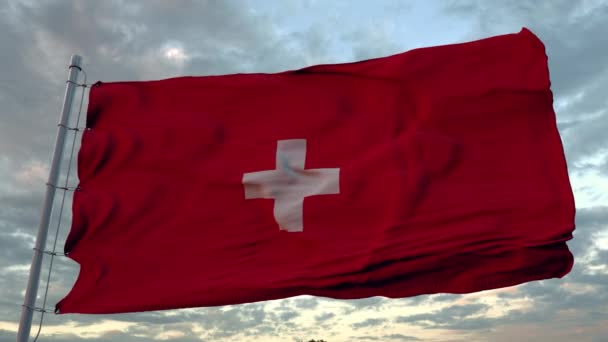 De nationale vlag van Zwitserland wappert in de wind tegen een blauwe lucht — Stockvideo