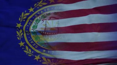 ABD ve New Hampshire Karışık Bayrağı rüzgarda dalgalanıyor. Bayrak direğinde New Hampshire ve ABD bayrağı