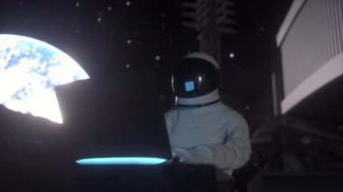 Astronot, Ay 'daki bir uzay kolonisinde bilim dizüstü bilgisayarı üzerinde çalışıyor.