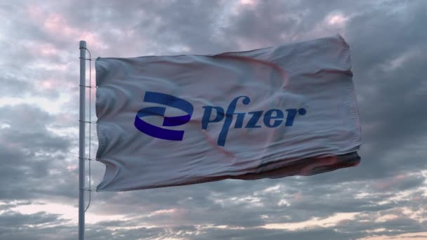 Белый флаг с новым логотипом Pfizer, размахивающим на ветру. Pfizer - американская фармацевтическая компания, производящая вакцину для коронавируса Covid-19 — стоковое видео