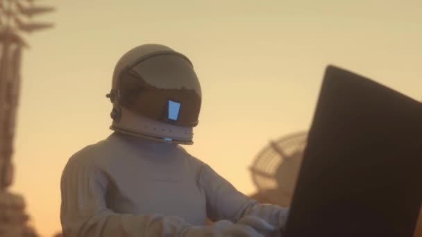 Astronauta trabalha em seu laptop científico em uma colônia espacial em um dos planetas — Vídeo de Stock