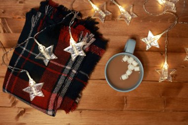 Masada lokum ve ışık olan bir fincan sıcak çikolata.