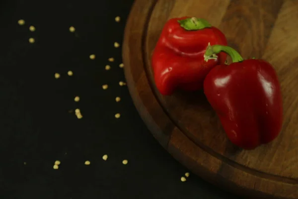 Pimentos vermelhos sobre fundo preto — Fotografia de Stock