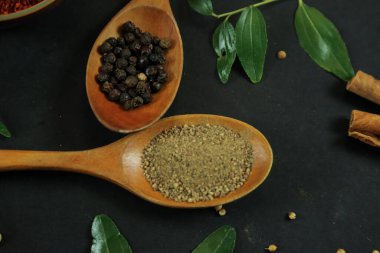 Siyah masanın arka planında geniş çeşitlilikte baharat ve bitkiler