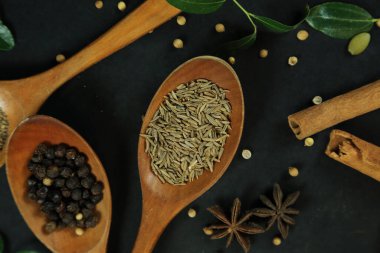 Siyah masanın arka planında geniş çeşitlilikte baharat ve bitkiler