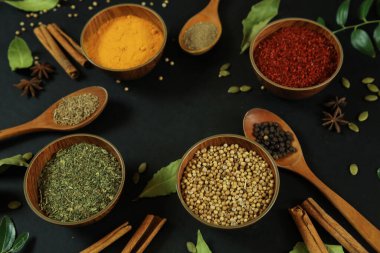 Siyah masanın arka planında geniş çeşitlilikte baharat ve bitkiler