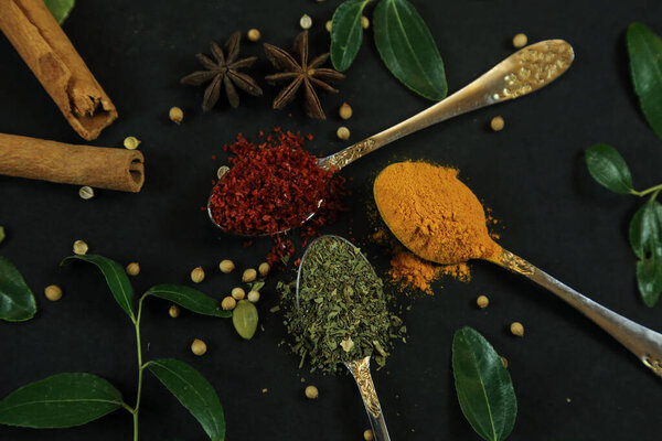 Wide variety spices and herbs on background of black table