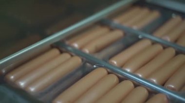 Otomatik bir makine tarafından üretilen et fabrikasında sosis işleniyor.