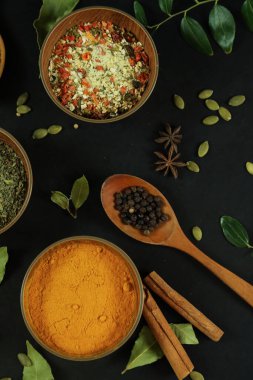 Siyah masanın arka planında geniş çeşitlilikte baharat ve bitkiler