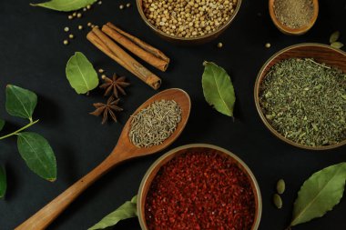 Siyah masanın arka planında geniş çeşitlilikte baharat ve bitkiler