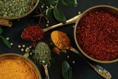 Siyah masanın arka planında geniş çeşitlilikte baharat ve bitkiler