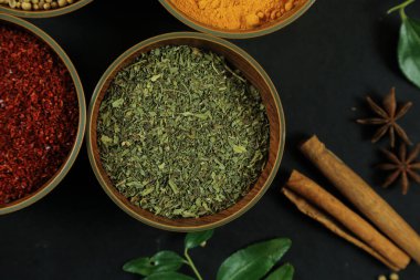 Siyah masanın arka planında geniş çeşitlilikte baharat ve bitkiler