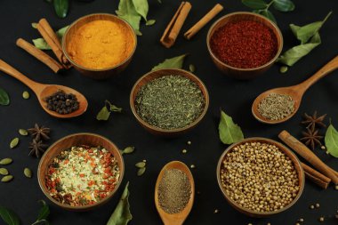 Siyah masanın arka planında geniş çeşitlilikte baharat ve bitkiler