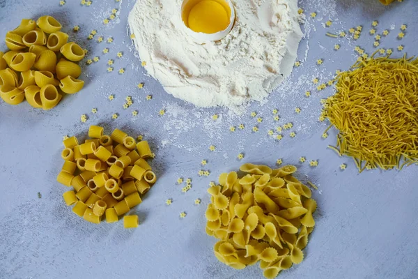 Ingredients for homemade pasta. Food background: macaroni, spagetti, egg, flour — Stock Photo, Image