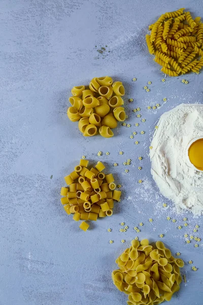 Ingredients for homemade pasta. Food background: macaroni, spagetti, egg, flour — Stock Photo, Image