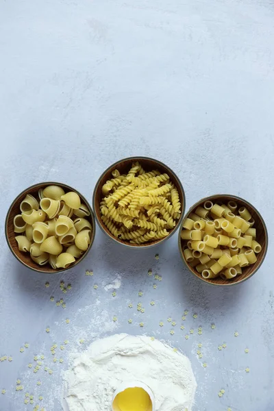 Ingredients for homemade pasta. Food background: macaroni, spagetti, egg, flour — Stock Photo, Image