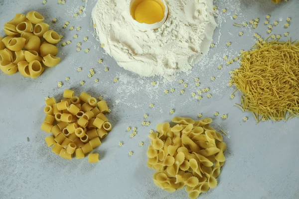 Ingredients for homemade pasta. Food background: macaroni, spagetti, egg, flour — Stock Photo, Image