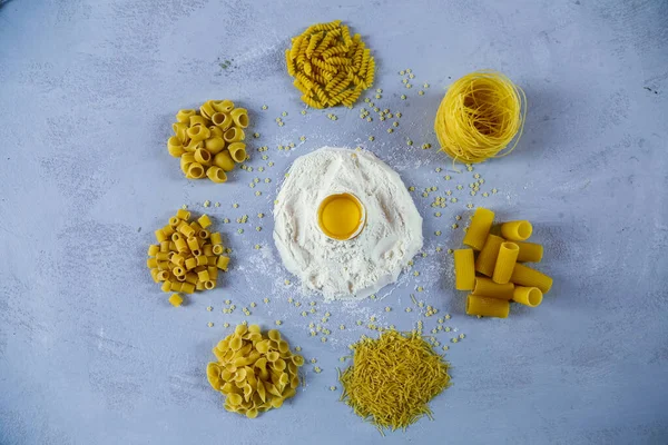 Ingredients for homemade pasta. Food background: macaroni, spagetti, egg, flour — Stock Photo, Image