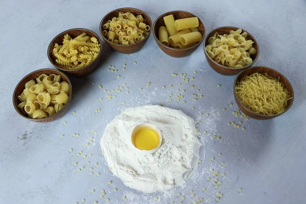 Ingredients for homemade pasta. Food background: macaroni, spagetti, egg, flour — Stock Photo, Image