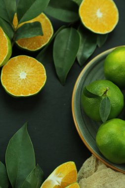 Arka planda yetişen yeşil tatlı mandalinalar