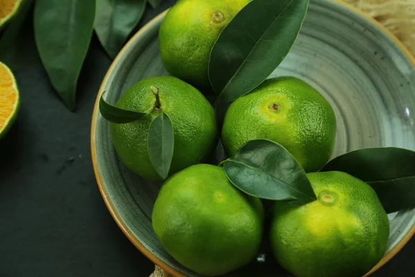 Mandarines douces vertes croissant avec le fond — Photo