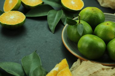 Arka planda yetişen yeşil tatlı mandalinalar