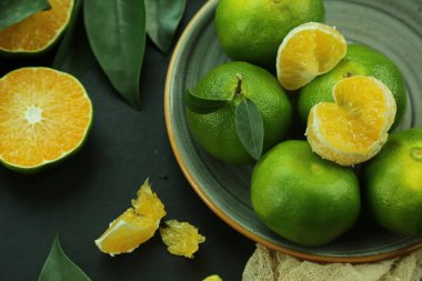 Arka planda yetişen yeşil tatlı mandalinalar