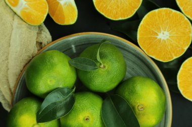 Arka planda yetişen yeşil tatlı mandalinalar