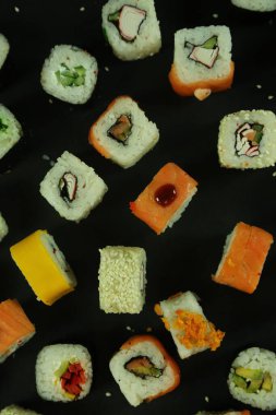 Somon, ton balığı, avokado ve salatalıklı suşi. Bir sürü rulo. Suşi rulo.