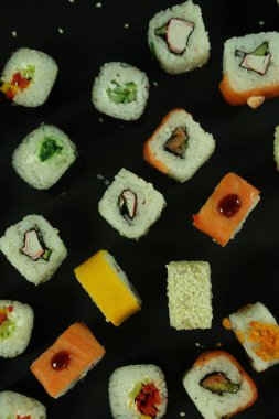 Somon, ton balığı, avokado ve salatalıklı suşi. Bir sürü rulo. Suşi rulo.