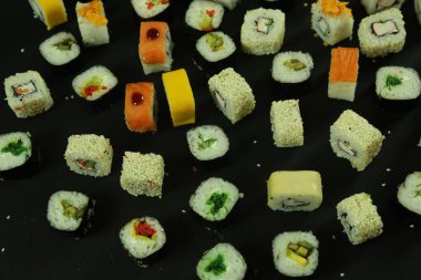 Somon, ton balığı, avokado ve salatalıklı suşi. Bir sürü rulo. Suşi rulo.