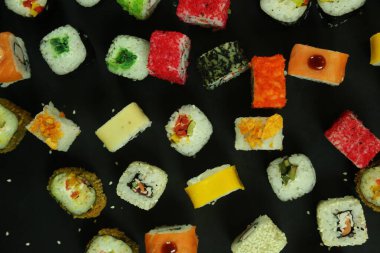 Somon, ton balığı, avokado ve salatalıklı suşi. Bir sürü rulo. Suşi rulo.