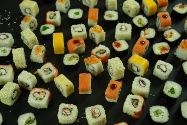 Somon, ton balığı, avokado ve salatalıklı suşi. Bir sürü rulo. Suşi rulo.