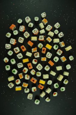 Somon, ton balığı, avokado ve salatalıklı suşi. Bir sürü rulo. Suşi rulo.