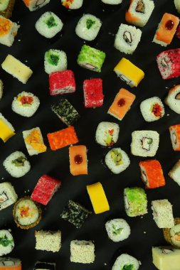 Somon, ton balığı, avokado ve salatalıklı suşi. Bir sürü rulo. Suşi rulo.