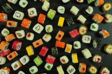 Somon, ton balığı, avokado ve salatalıklı suşi. Bir sürü rulo. Suşi rulo.