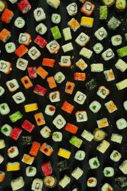 Somon, ton balığı, avokado ve salatalıklı suşi. Bir sürü rulo. Suşi rulo.