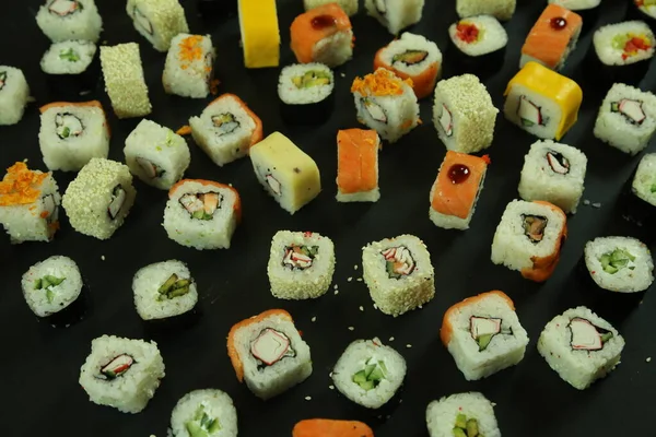 寿司はサーモン、マグロ、アボカド、キュウリで転がします。多くのロール。寿司巻き. — ストック写真