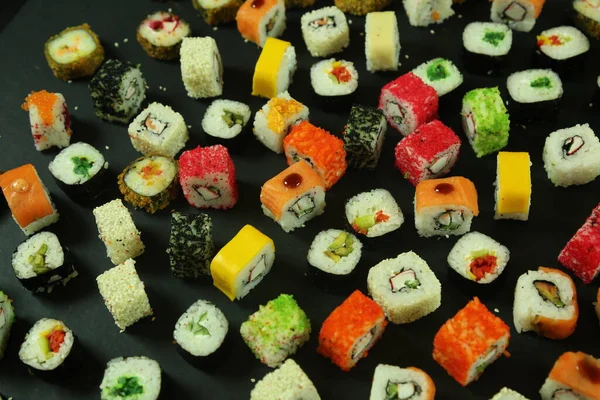 寿司はサーモン、マグロ、アボカド、キュウリで転がします。多くのロール。寿司巻き. — ストック写真