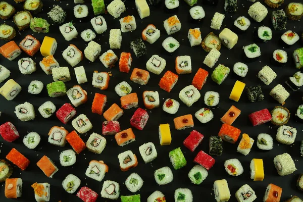 Somon, ton balığı, avokado ve salatalıklı suşi. Bir sürü rulo. Suşi rulo.