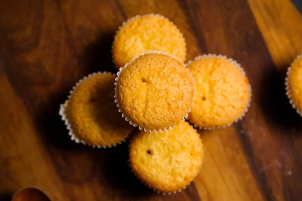 Cupcakes em um fundo de madeira. Cozimento — Fotografia de Stock